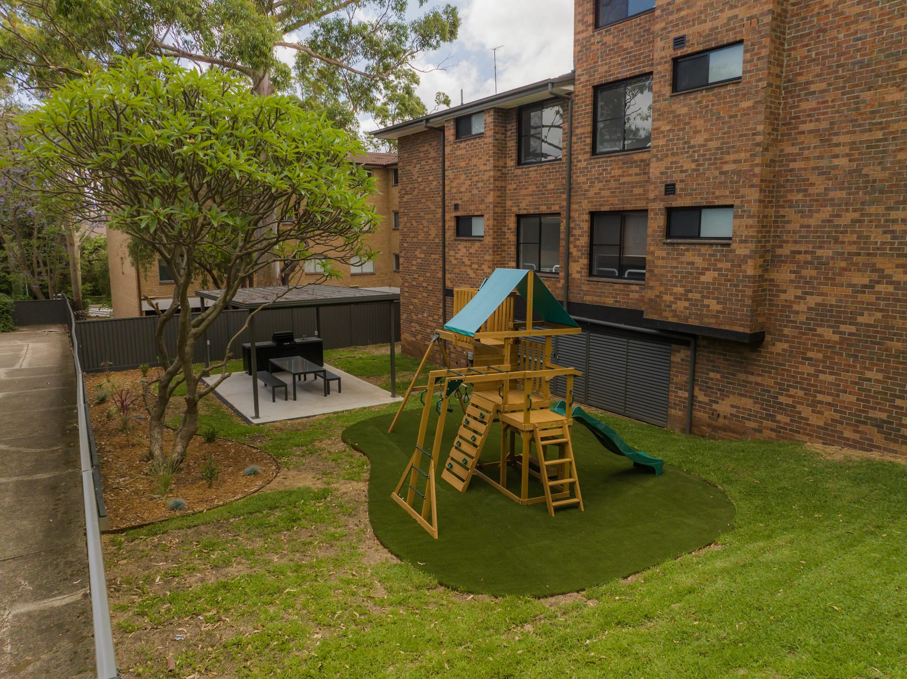 Courtyard landscaping with synthetic turf and outdoor entertaining area